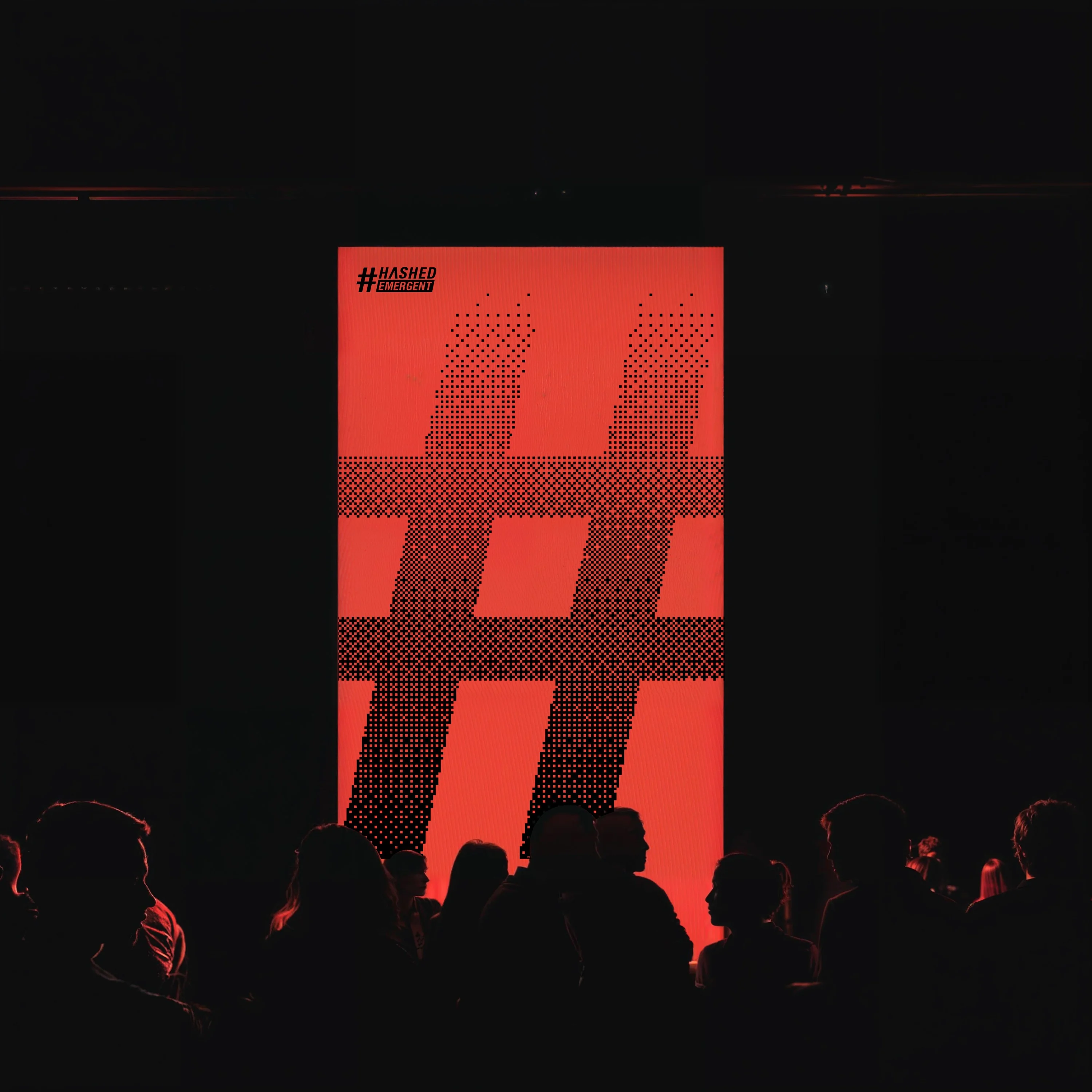 Launch event screen showing oversized hashtag symbol in red with audience silhouettes